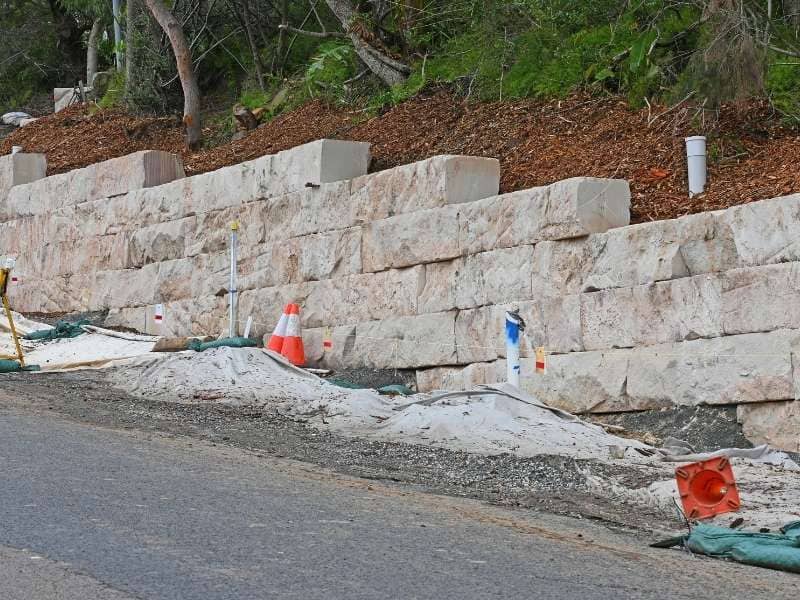 Retaining wall built on a sloped construction site, demonstrating how a topographic survey supports hillside grading, drainage, and foundation planning before construction.