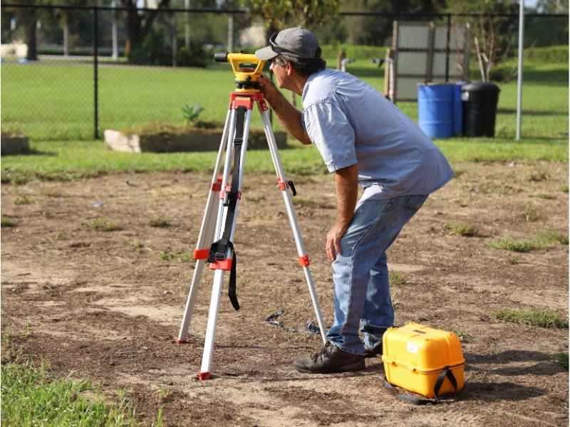 Property line markers in Cincinnati, Ohio, being verified by a land surveyor before replacing a retaining wall.